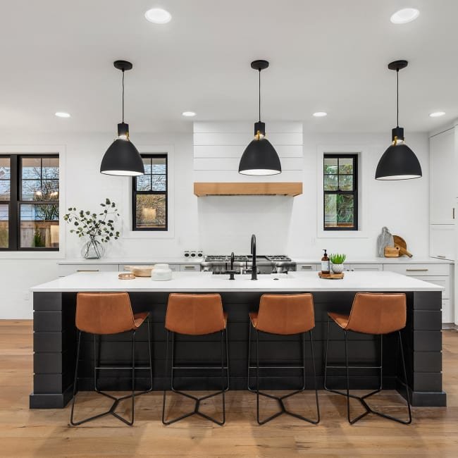 black kitchen island with white countertop and brown hardwood floor from Lonsdale Flooring in Vancouver, BC